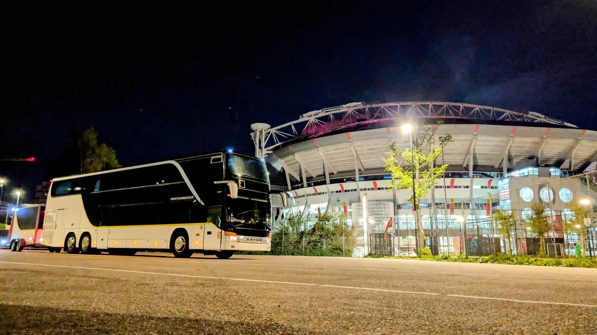 FTL nightliner and trailer parked at a stadium at night